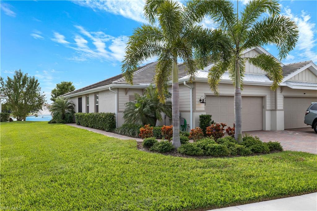 14558 Edgewater Circle Naples, FL 34114 - Photo 2 of 40 a front view of a house with a garden and plants