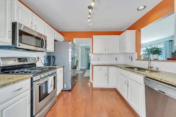 a spacious bedroom with a bed chandelier and a window