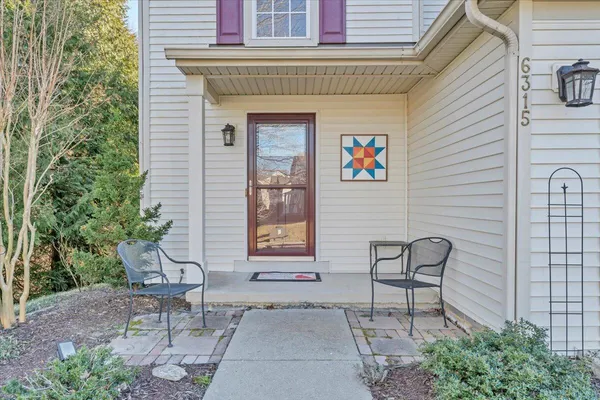 a front view of a house with outdoor seating and trees
