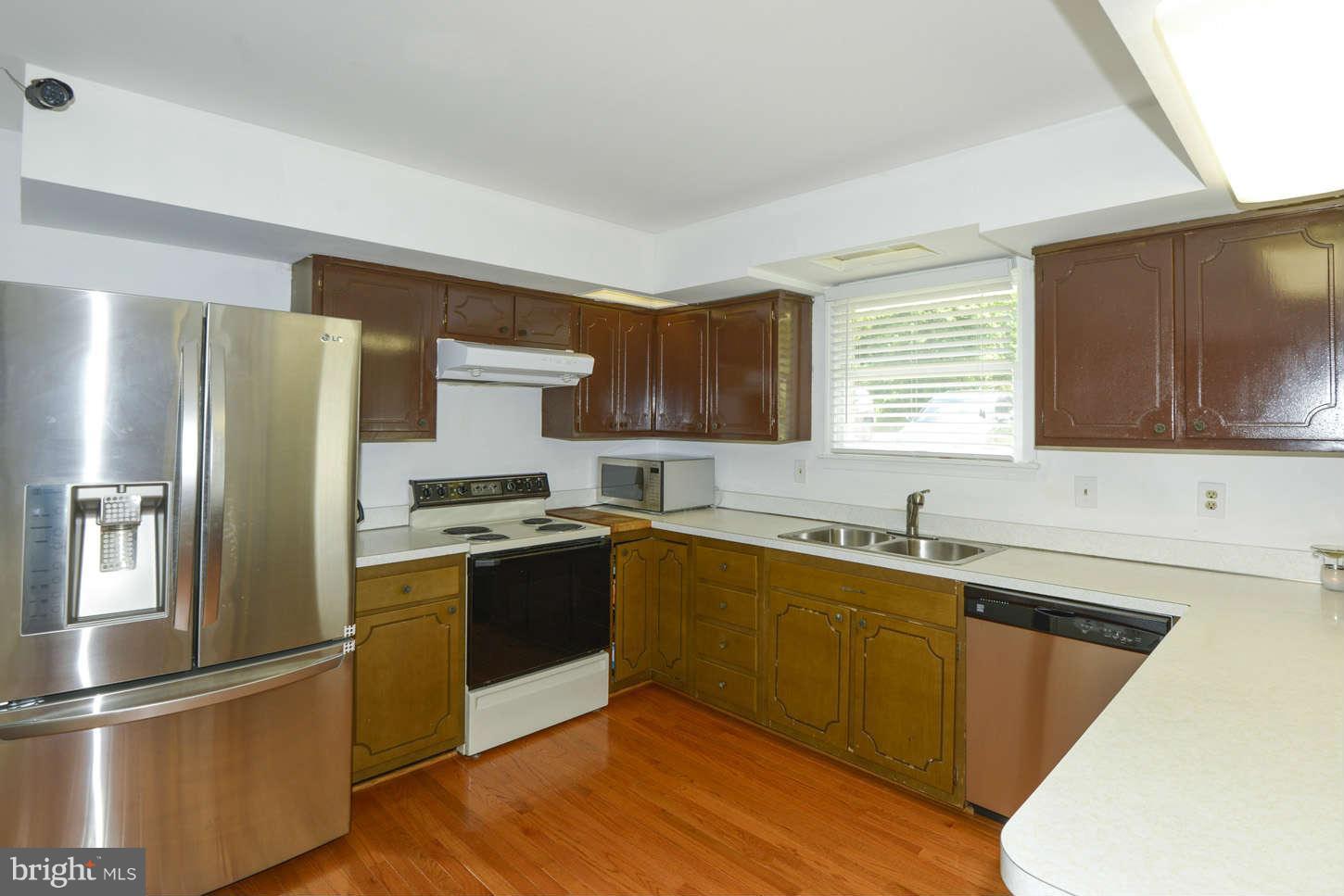 16590 Brogden Road Spencerville, MD 20868 - Photo 8 of 19 a kitchen with stainless steel appliances granite countertop a refrigerator sink and wooden cabinets