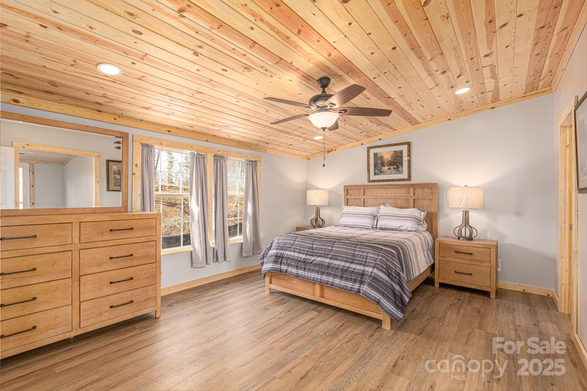459 Vaughan Road Spruce Pine, NC 28777 - Photo 16 of 35 a spacious bedroom with a large bed and a chandelier