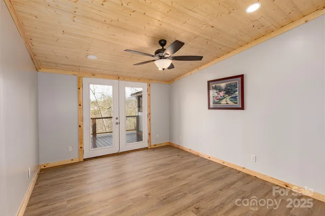 an empty room with wooden floor and ceiling fan