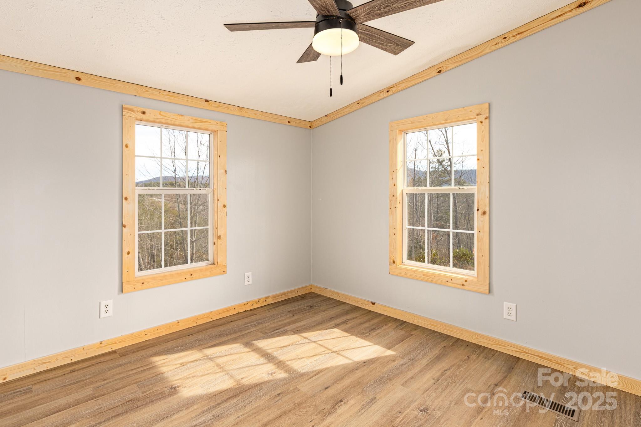 459 Vaughan Road Spruce Pine, NC 28777 - Photo 23 of 35 an empty room with wooden floor fan and windows