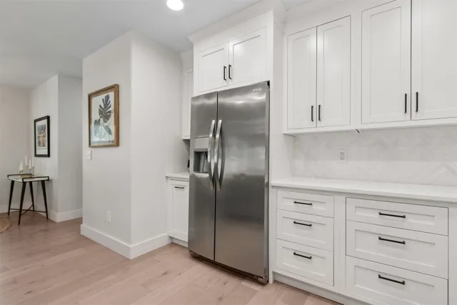 a kitchen with white cabinets and stainless steel appliances