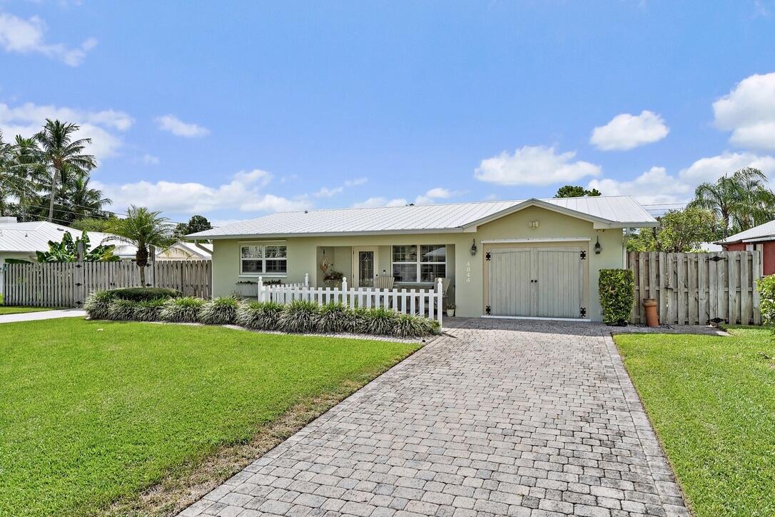 4844 Southeast Pilot Way Stuart, FL 34997 - Photo 1 of 41 a front view of a house with a yard and garage