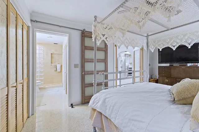 a bedroom with a large bed and a chandelier