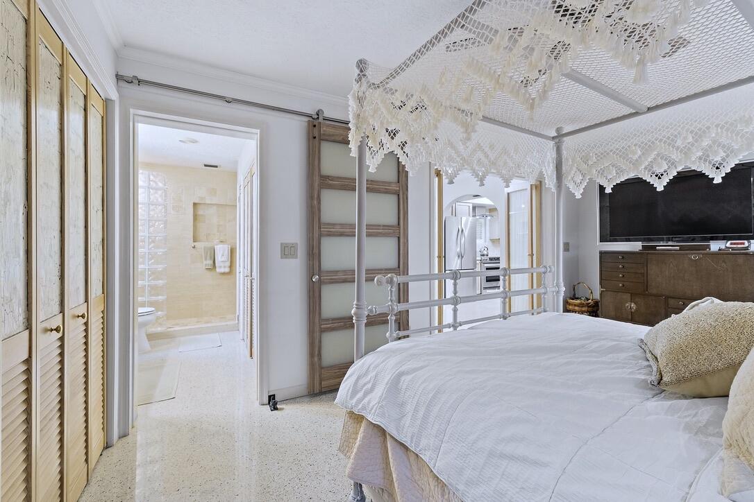 4844 Southeast Pilot Way Stuart, FL 34997 - Photo 18 of 41 a bedroom with a large bed and a chandelier