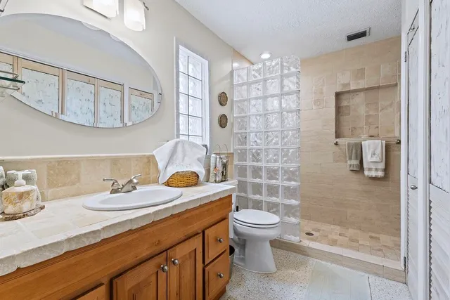 a bathroom with a sink a toilet and shower