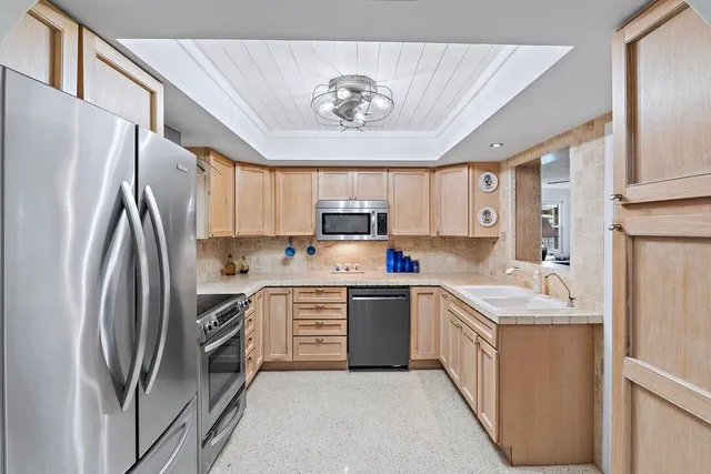 a kitchen with stainless steel appliances granite countertop a refrigerator sink and stove