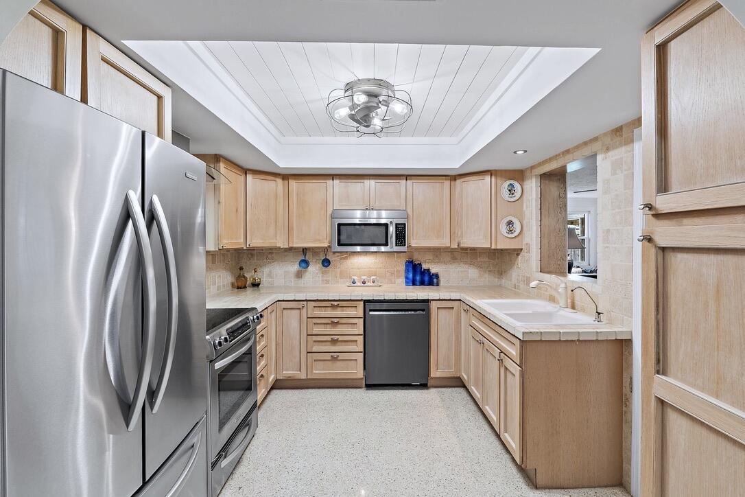 4844 Southeast Pilot Way Stuart, FL 34997 - Photo 7 of 41 a kitchen with stainless steel appliances granite countertop a refrigerator sink and stove