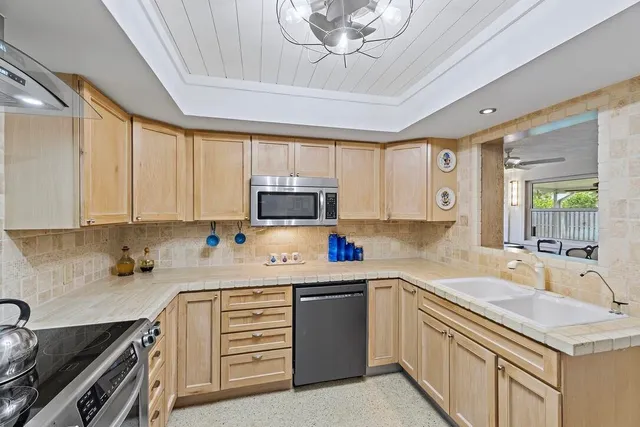a kitchen with stainless steel appliances granite countertop a sink dishwasher stove and refrigerator with wooden floor