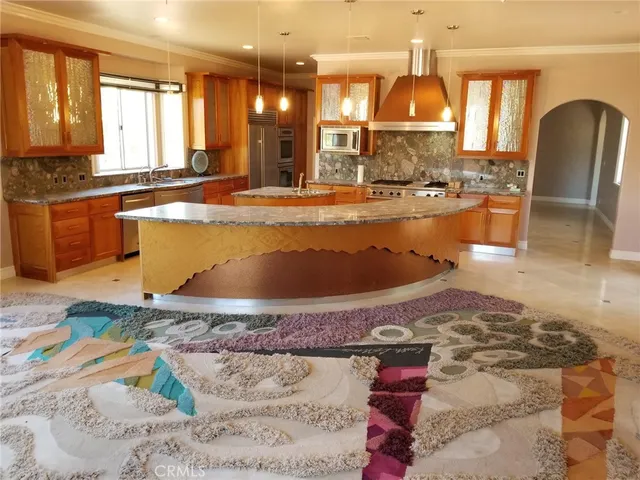 a view of a kitchen with stainless steel appliances wooden floor and a window