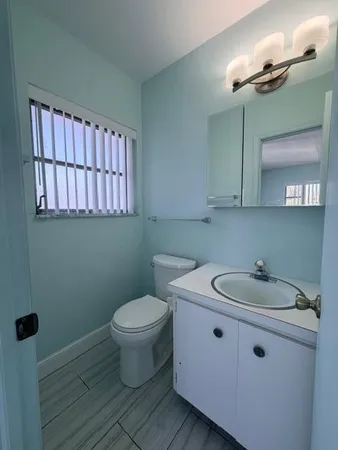 a bathroom with a toilet sink and mirror