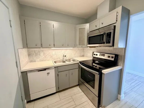 a kitchen with stainless steel appliances granite countertop a sink stove and microwave