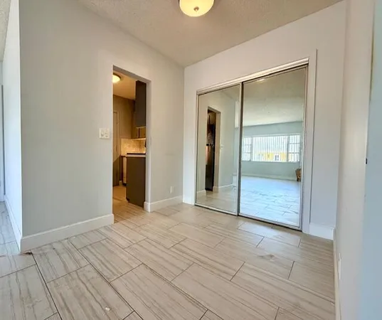 a view of a hallway with wooden floor and a bathroom
