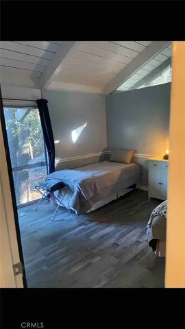 a living room with a bed furniture and a large window