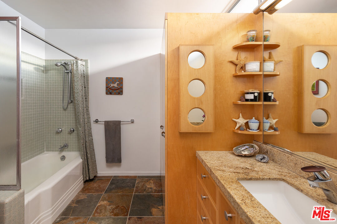 721 Rochedale Way Los Angeles, CA 90049 - Photo 15 of 25 a bathroom with a granite countertop sink a mirror and shower