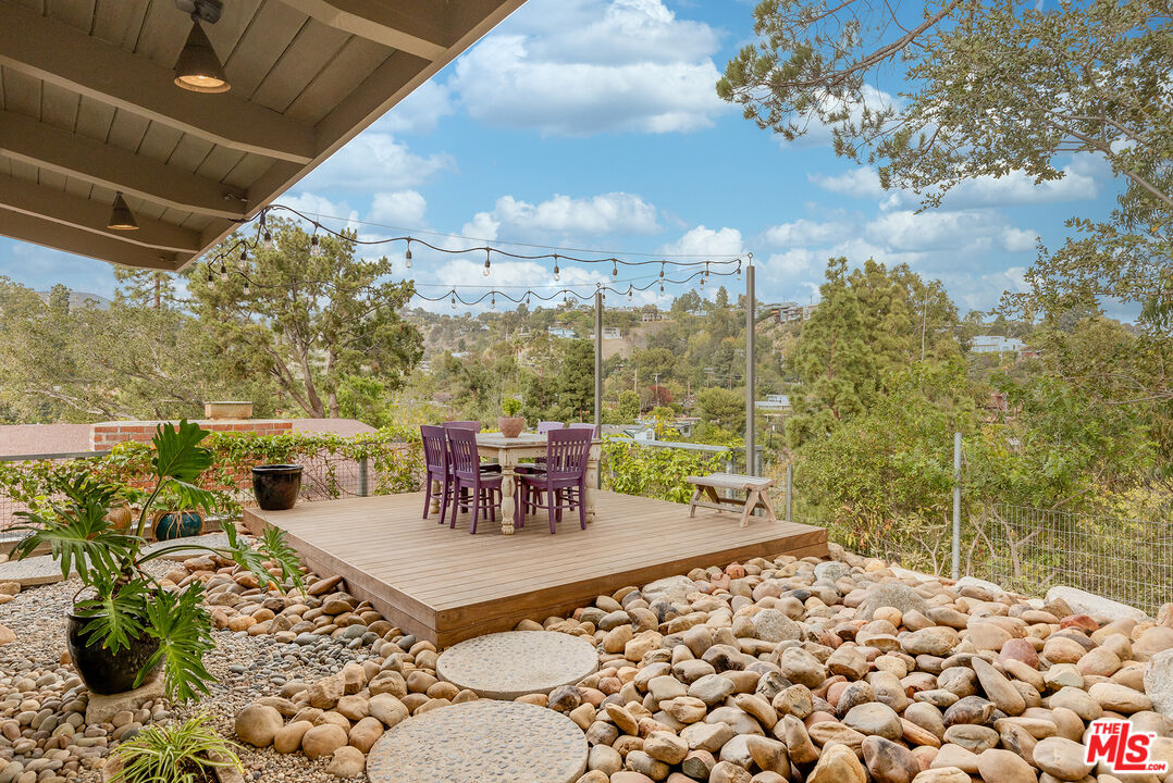 721 Rochedale Way Los Angeles, CA 90049 - Photo 19 of 25 a roof deck with table and chairs and potted plants