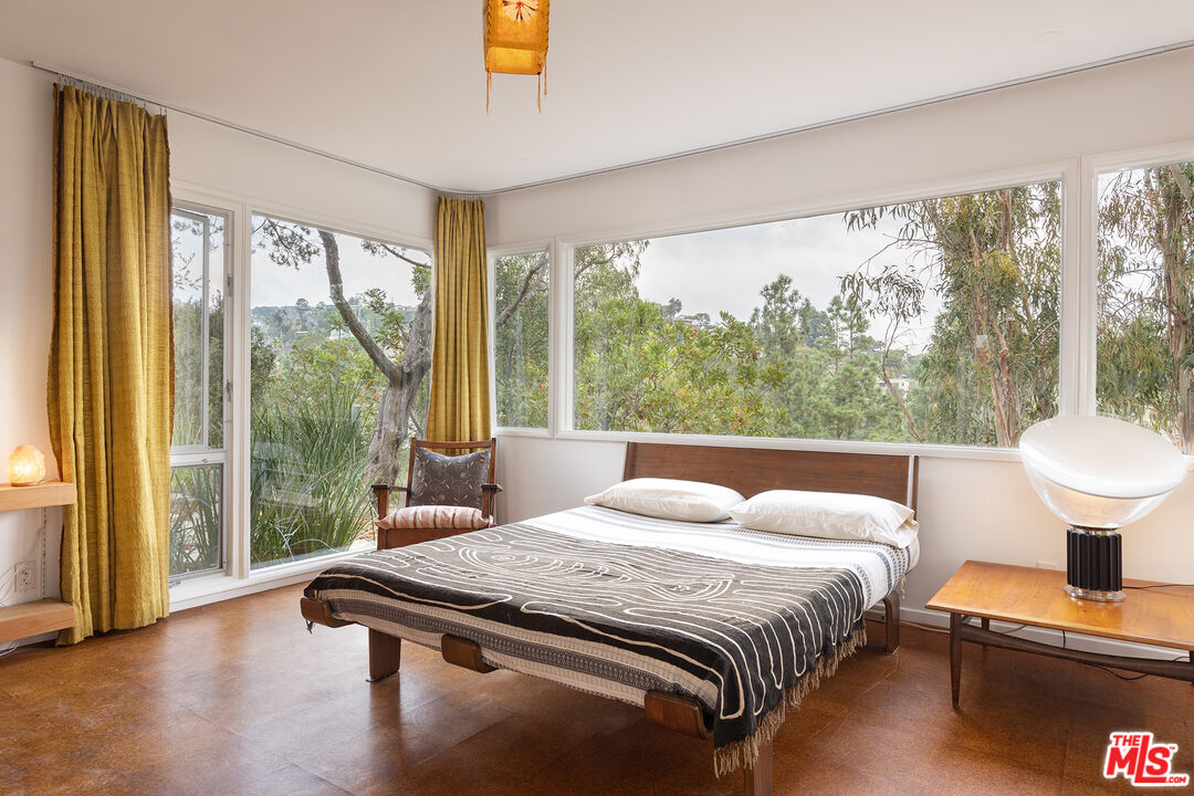721 Rochedale Way Los Angeles, CA 90049 - Photo 9 of 25 a bedroom with a bed and a lamp next to a large window