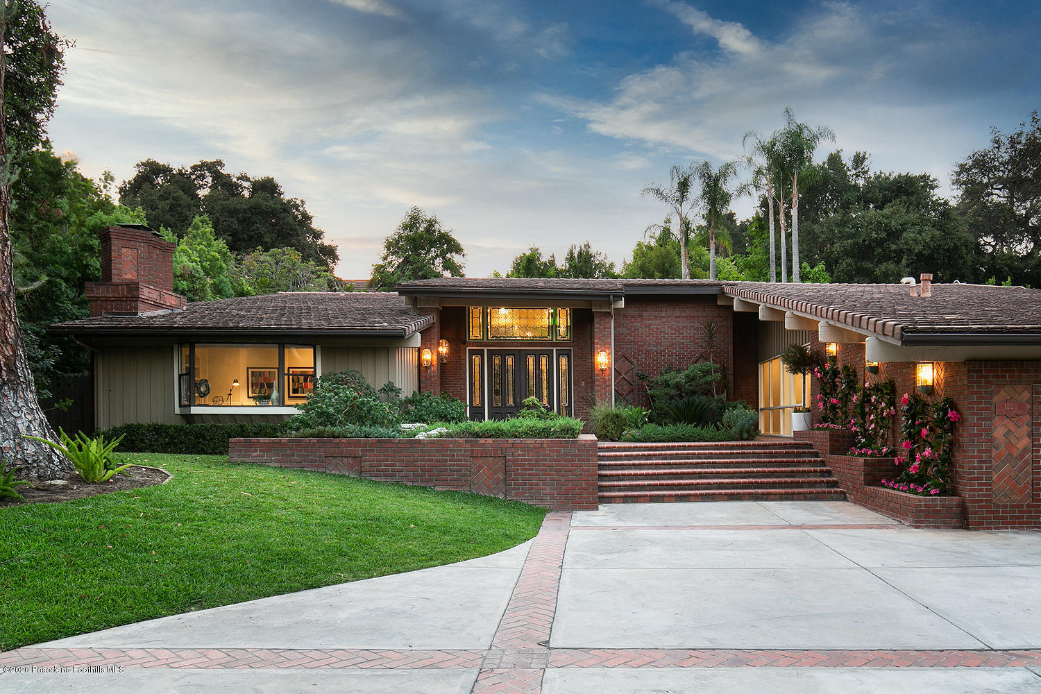 a front view of a house with a yard and trees