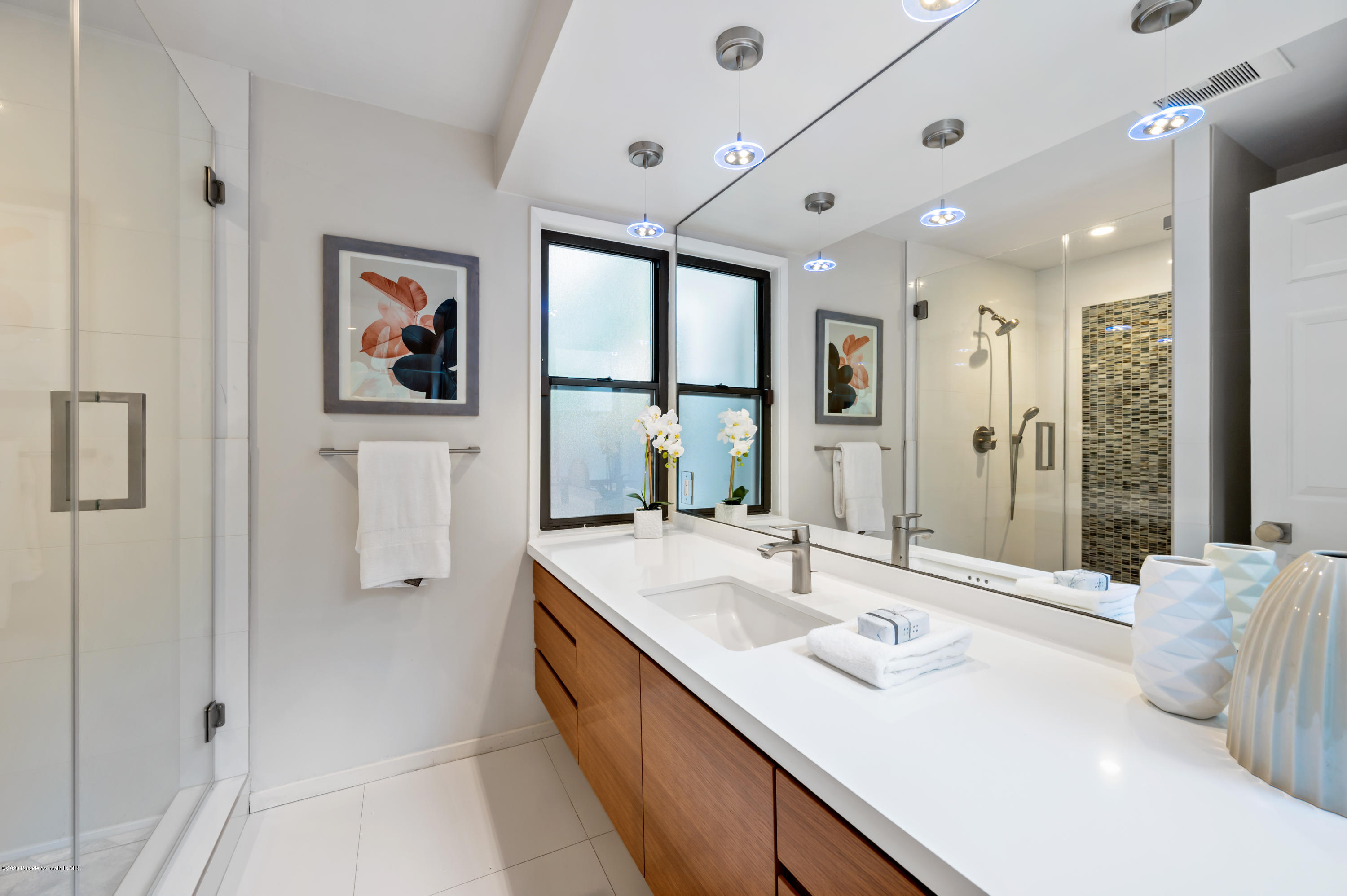 1225 Mesa Road San Marino, CA 91108 - Photo 22 of 48 a en suite bathroom with a sink a large mirror and a shower