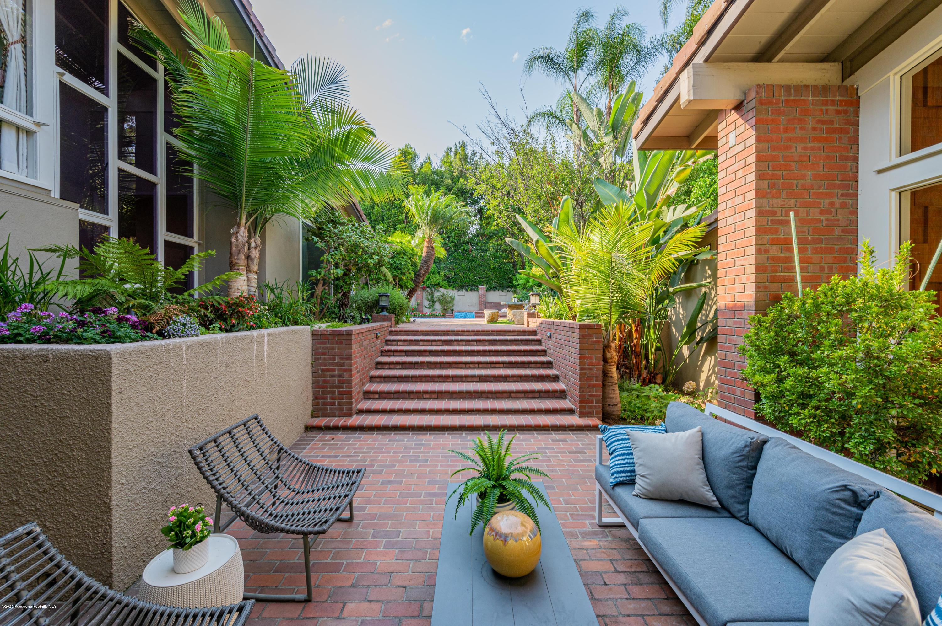 1225 Mesa Road San Marino, CA 91108 - Photo 8 of 48 a view of a patio with couches table and chairs potted plants and palm trees