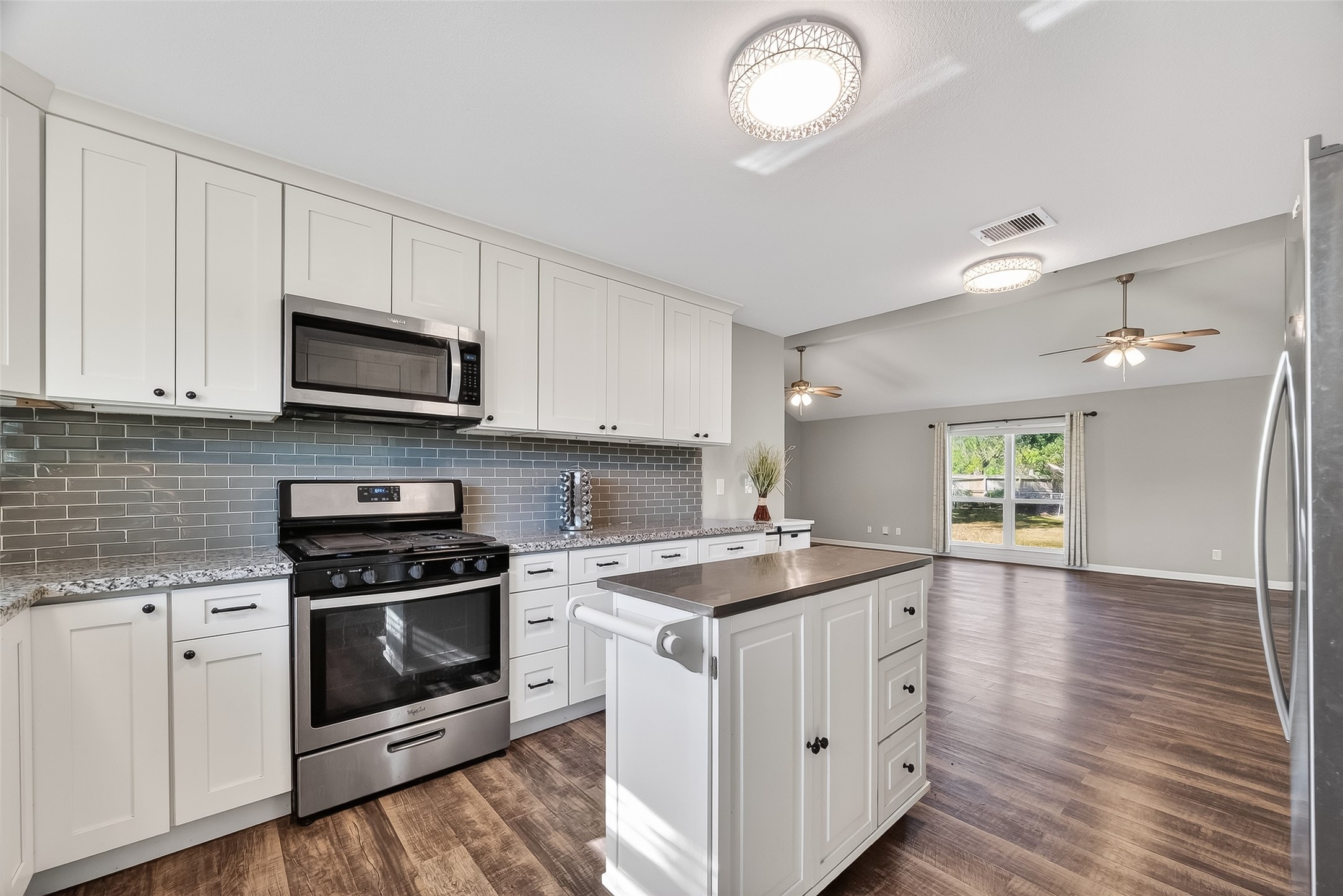 12430 Eiker Road Pearland, TX 77581 - Photo 11 of 41 a kitchen with a stove a sink and wooden floor