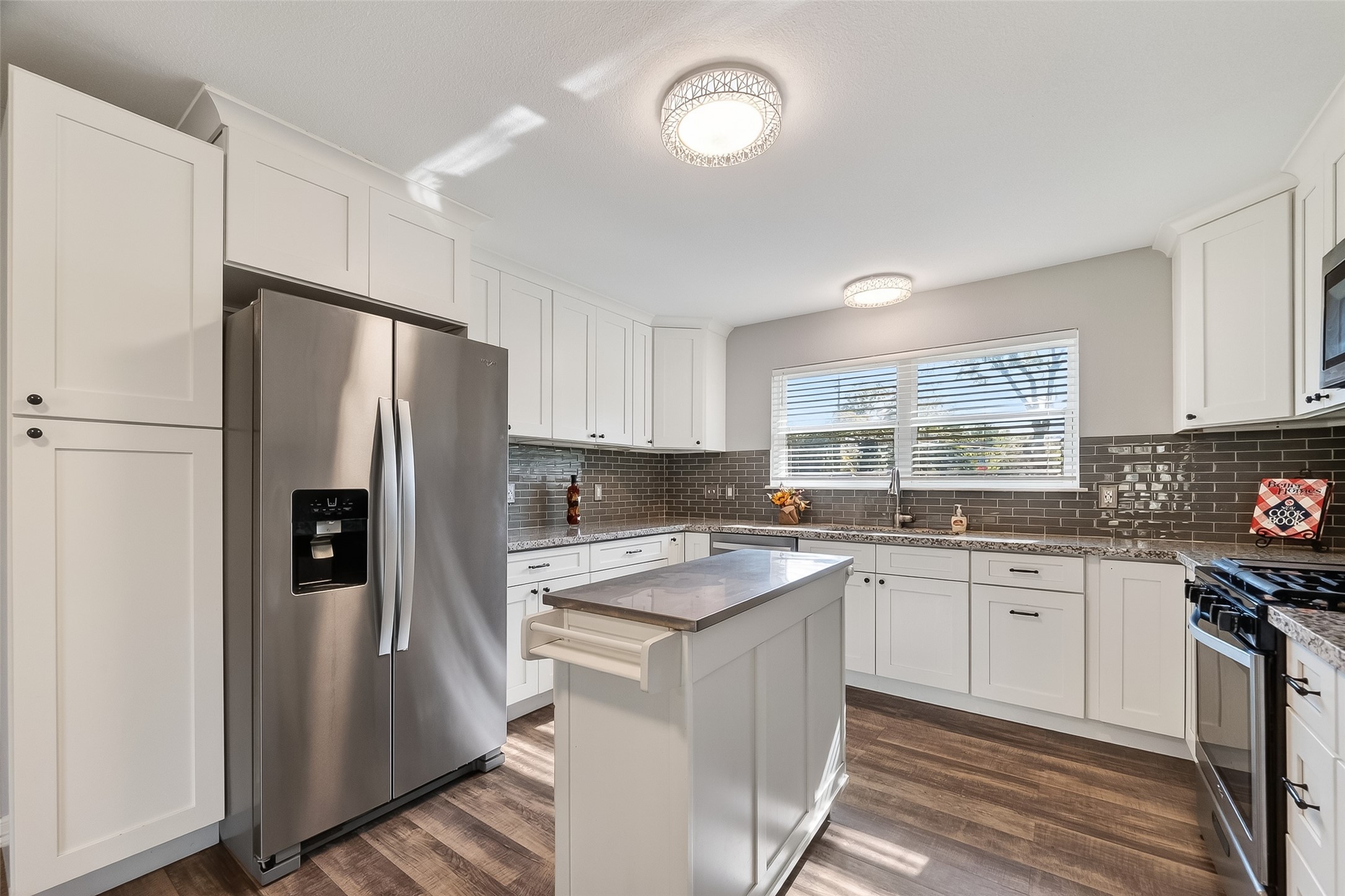 12430 Eiker Road Pearland, TX 77581 - Photo 13 of 41 a kitchen with a refrigerator a sink and cabinets