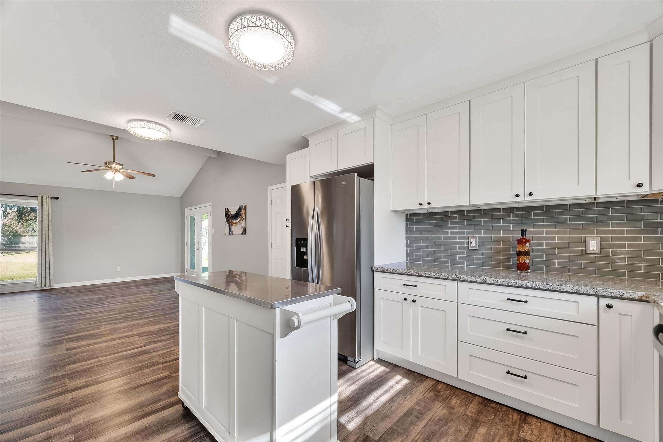 12430 Eiker Road Pearland, TX 77581 - Photo 14 of 41 a kitchen with kitchen island granite countertop a sink cabinets and stainless steel appliances