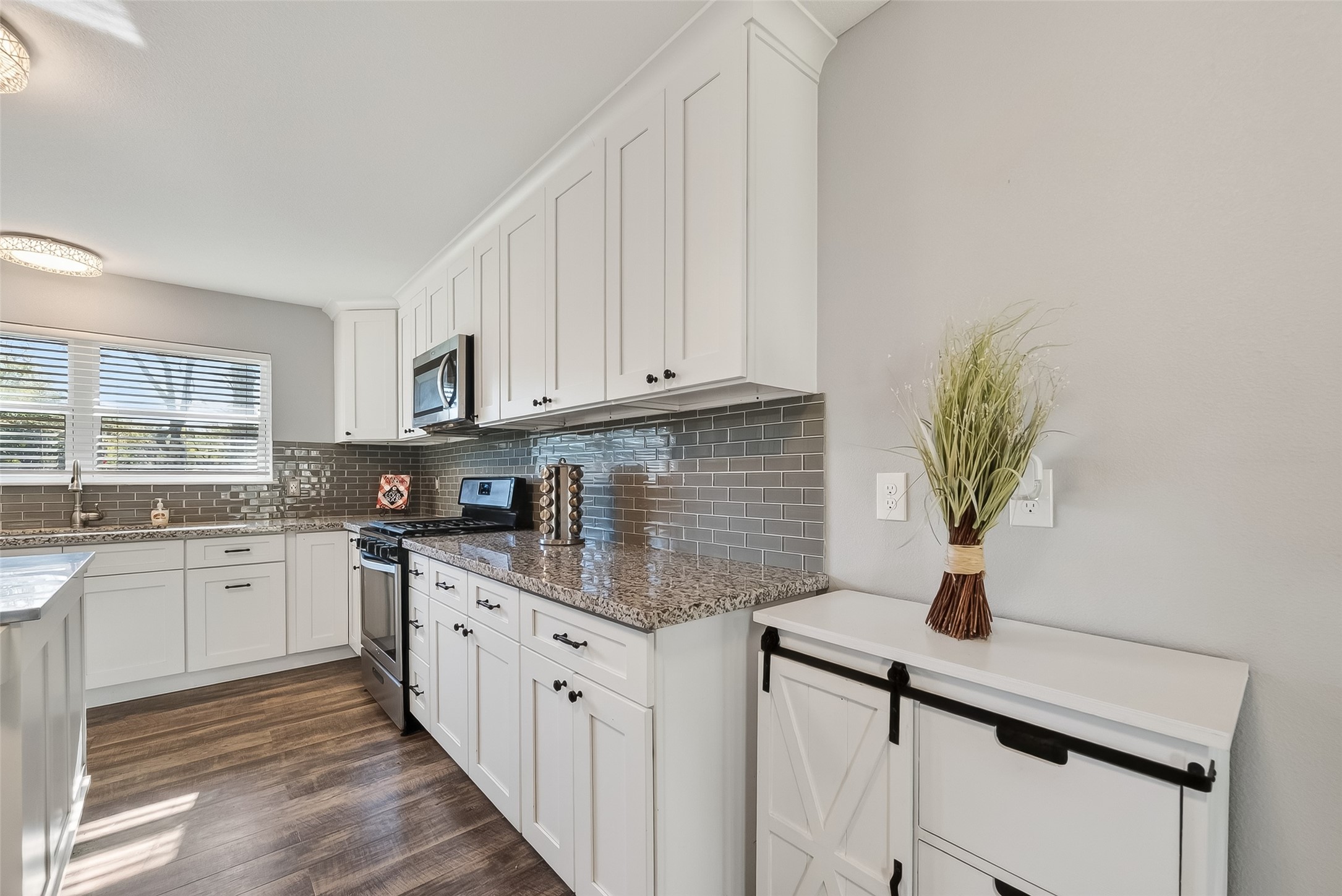 12430 Eiker Road Pearland, TX 77581 - Photo 15 of 41 a kitchen with stainless steel appliances granite countertop a sink a stove cabinets and a counter top space