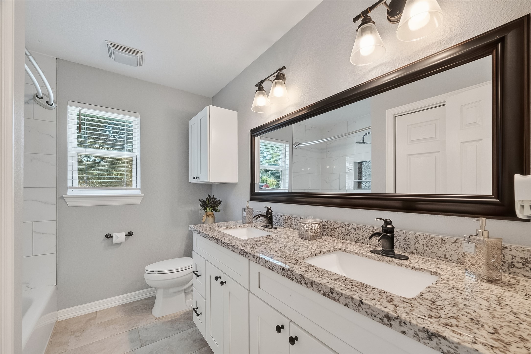 12430 Eiker Road Pearland, TX 77581 - Photo 19 of 41 a bathroom with a granite countertop sink mirror and a toilet