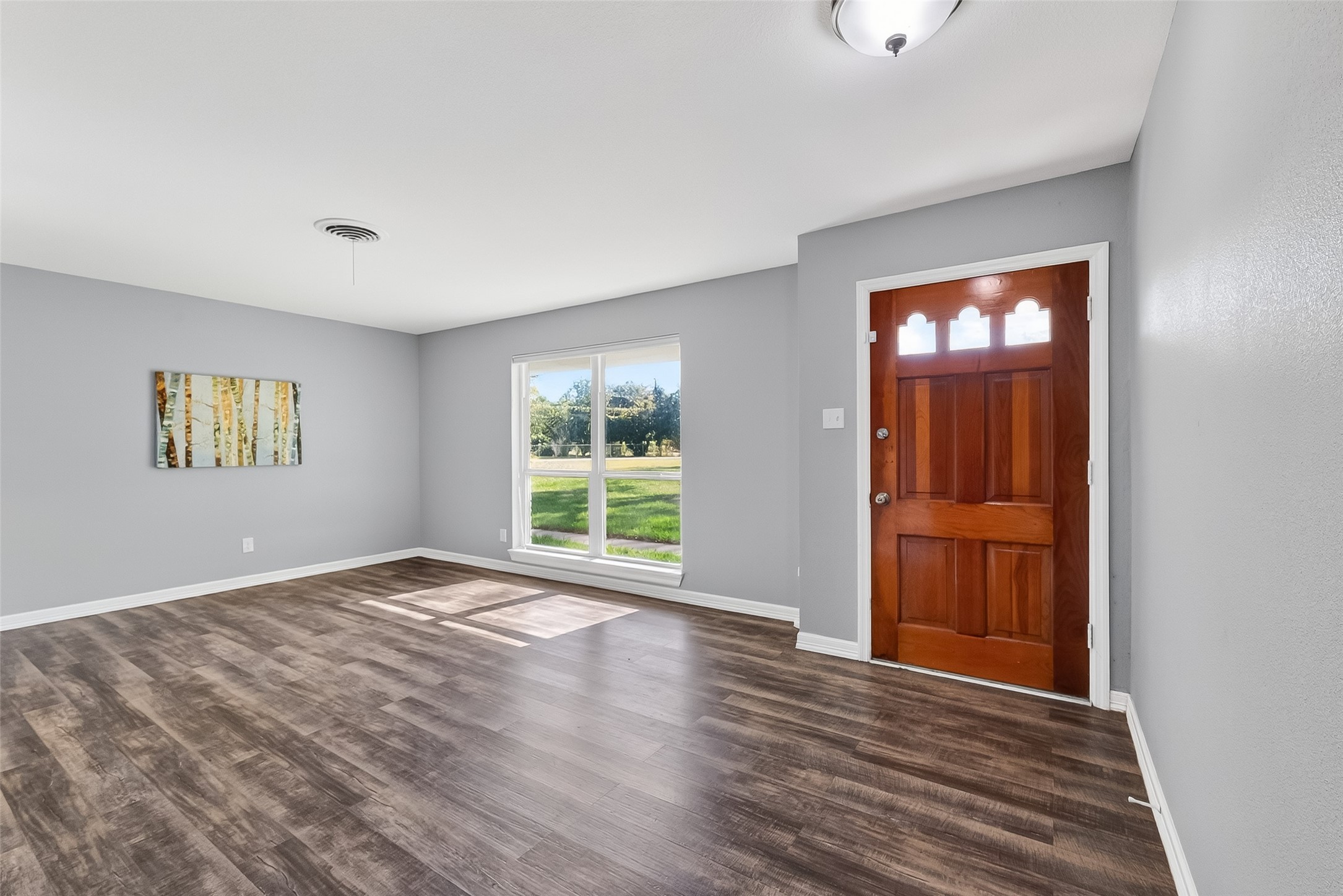 12430 Eiker Road Pearland, TX 77581 - Photo 4 of 41 a view of an empty room with wooden floor and a window