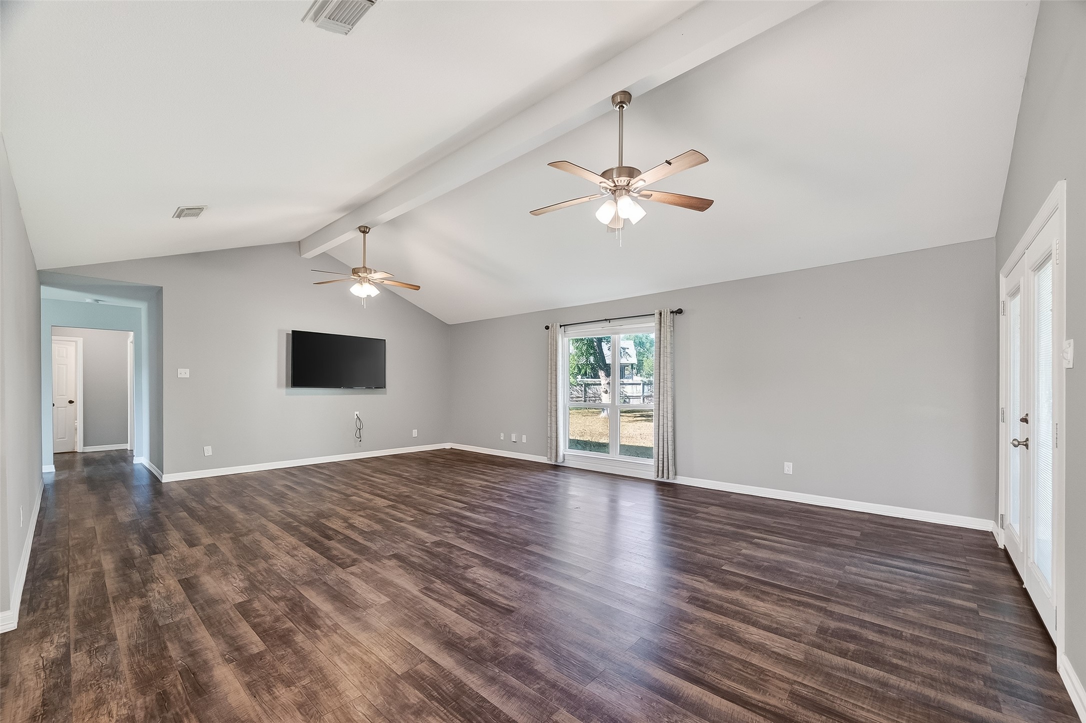 12430 Eiker Road Pearland, TX 77581 - Photo 8 of 41 an empty room with wooden floor chandelier fan and windows