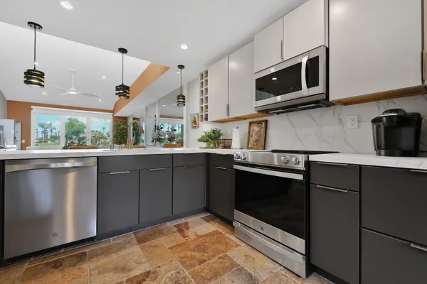 a kitchen with stainless steel appliances granite countertop a stove a microwave and a sink