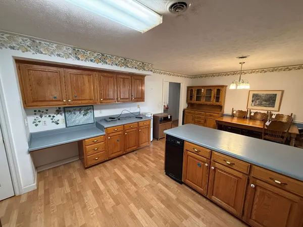a large kitchen with stainless steel appliances granite countertop a stove a sink dishwasher and cabinets with wooden floor
