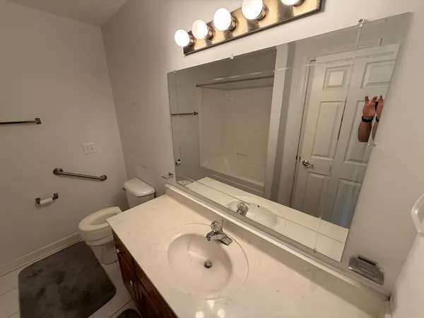 a bathroom with a sink and mirror with toilet
