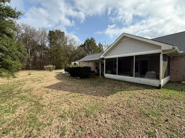 a view of house with backyard space and balcony