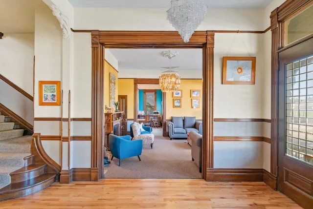a living room with furniture a chandelier and a large window