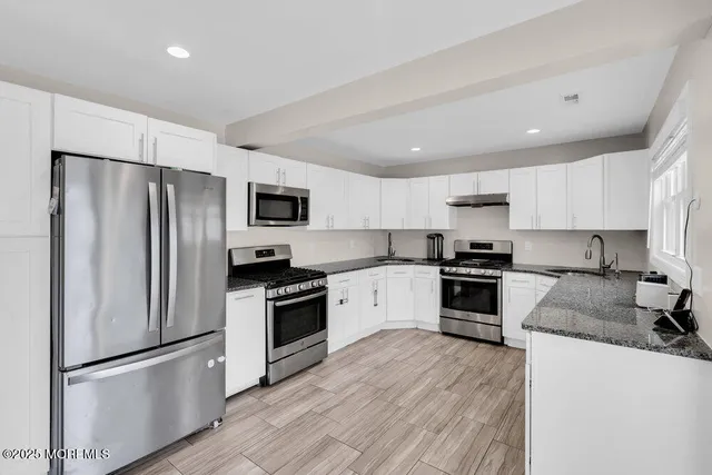 a kitchen with granite countertop stainless steel appliances and wooden cabinets