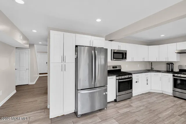 a kitchen with stainless steel appliances a refrigerator and a stove top oven