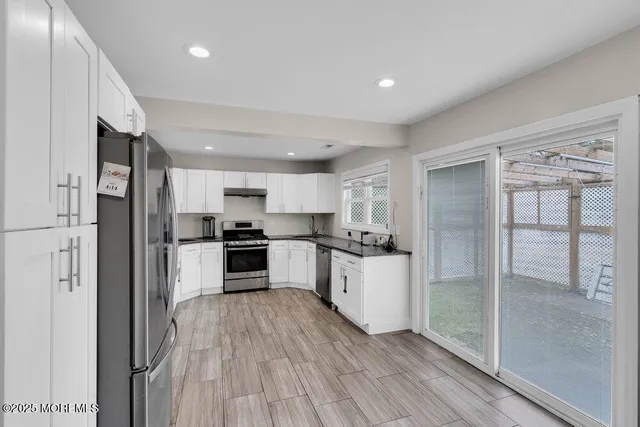a kitchen with white cabinets and stainless steel appliances