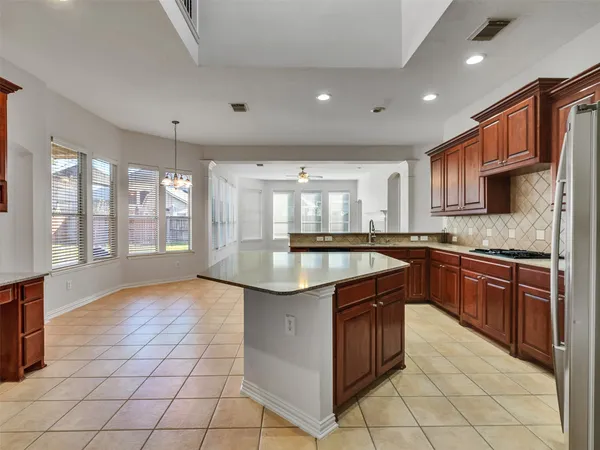 a kitchen with stainless steel appliances granite countertop a stove a sink and a microwave