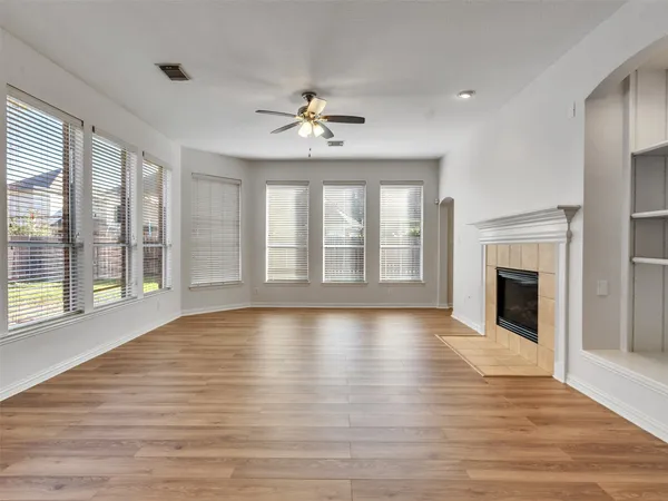 a view of an empty room with exposed radiator and fireplace
