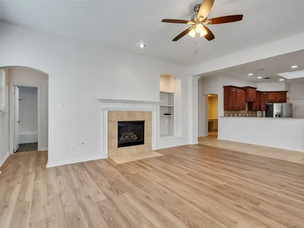 a view of empty room with wooden floor and a fireplace