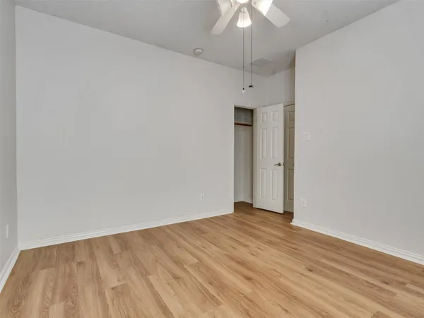 a view of an empty room with a chandelier fan