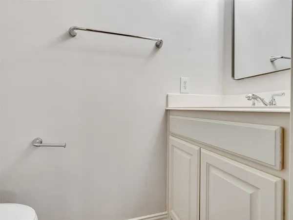 a bathroom with a sink vanity and toilet