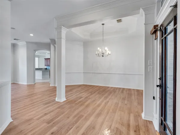 a view of empty room with wooden floor and window