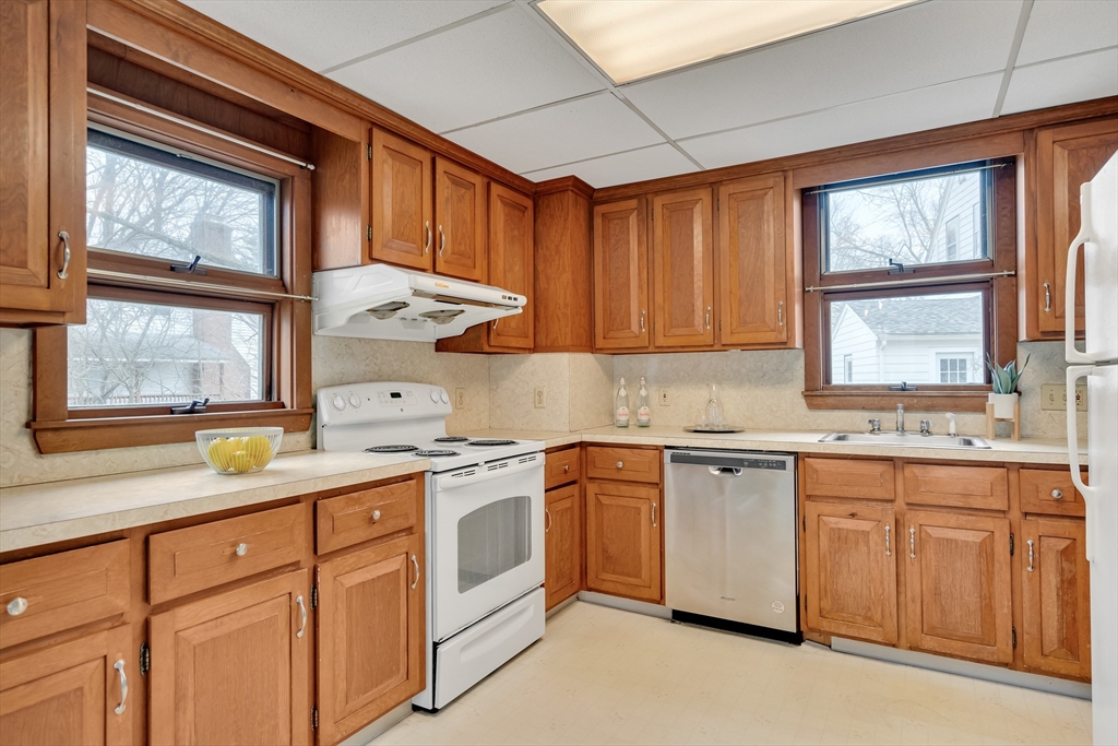 32 Valentine Road Arlington, MA 02476 - Photo 17 of 38 a kitchen with stainless steel appliances granite countertop a stove a sink dishwasher and cabinets with wooden floor