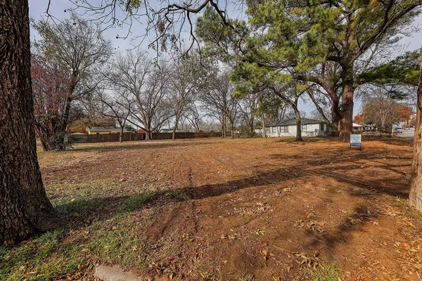 a view of dirt yard with a tree