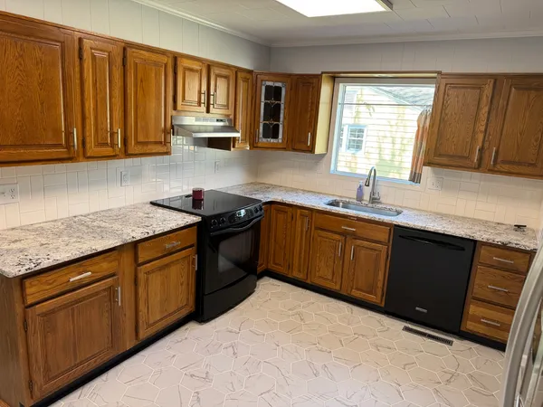 a kitchen with stainless steel appliances granite countertop wooden cabinets a sink and dishwasher